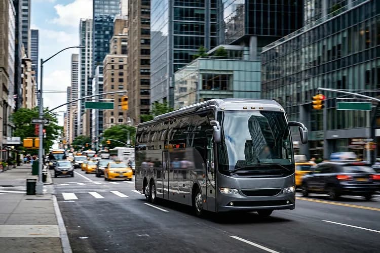 Silver charter bus on New York city street.